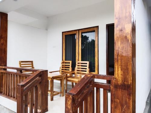 a balcony with chairs and a table and windows at Nan Bungalows Tetebatu in Tetebatu