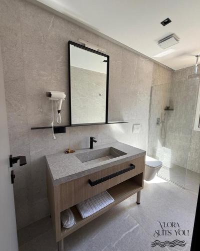 a bathroom with a sink and a mirror and a toilet at Apandnrosm in Vlorë