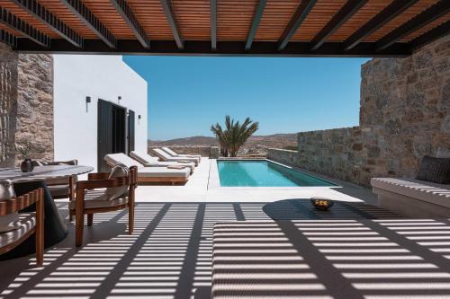 a patio with a swimming pool and a villa at Noir Mykonos in Mýkonos City