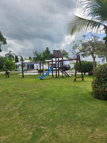 a playground with a swing set in a park at Villa en Ibiza Residence II, disfruta en familia in Río Hato