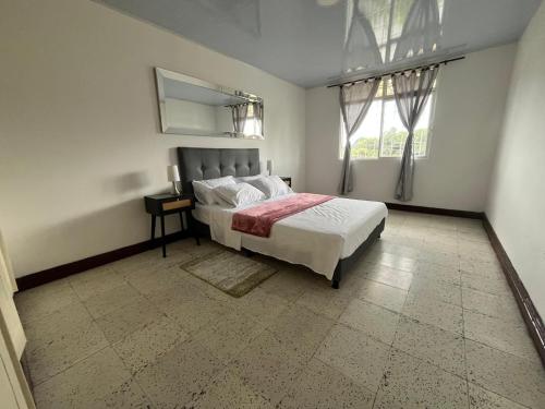 a bedroom with a bed and a window at ACOGEDOR APARTAMENTO DISPONIBLE eN CALARCA QUINDIO EXCELENTE UBICACION EN CONJUNTO CERRADO 2 HABITACIONES PARKING BIEN EQUIPADO in Calarcá