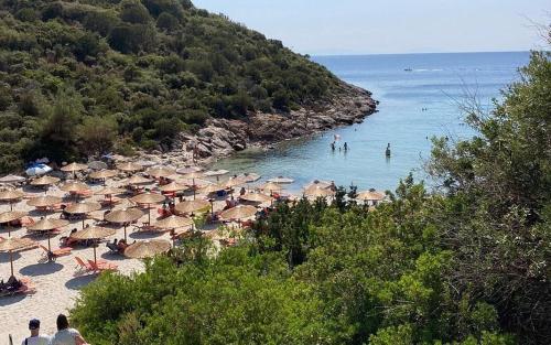 een strand met veel parasols en mensen in het water bij Lemon tree House in Skala Marion