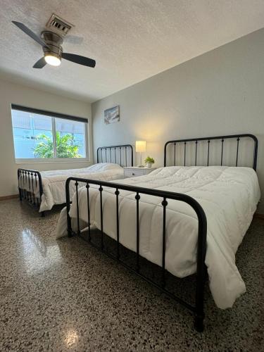 Un dormitorio con dos camas y un ventilador de techo. en Renew Apart - Our Home Pompano, en Pompano Beach