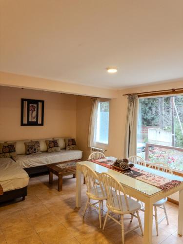 a living room with a couch and a table and chairs at Casa Llao alojamiento de montaña in San Carlos de Bariloche