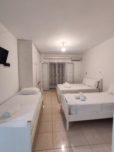 a room with three beds and a window at Villa Sidorela in Ksamil