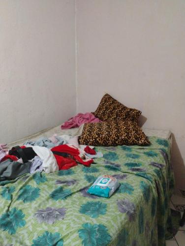 a unmade bed with a blanket and pillows on it at Casa familiar deep in Porto Seguro