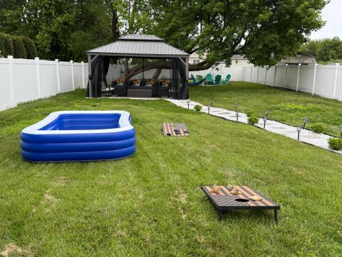 a backyard with a gazebo and a table and a blue inflatable at Ground-level bed bath house1mi to the beach sleep8 in Long Branch