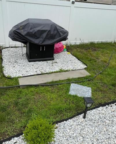a tv with a black cover on top of a yard at Ground-level bed bath house1mi to the beach sleep8 in Long Branch