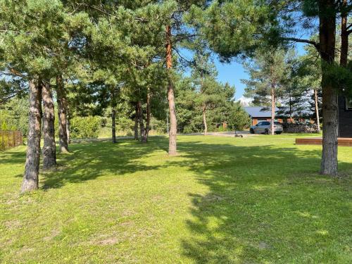 a park with trees and a bench in the grass at MyHouse Silla Pärnu Holiday House in Silla