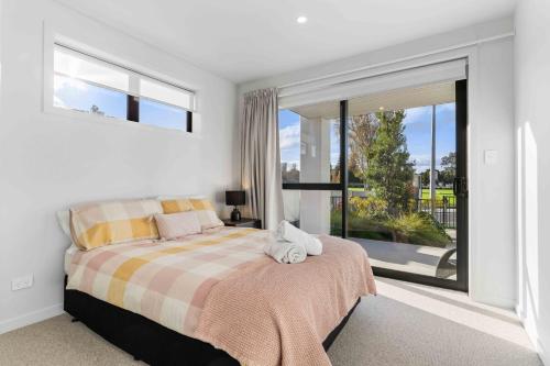 a bedroom with a bed and a large window at Memorial View - Tauranga Holiday Home in Tauranga