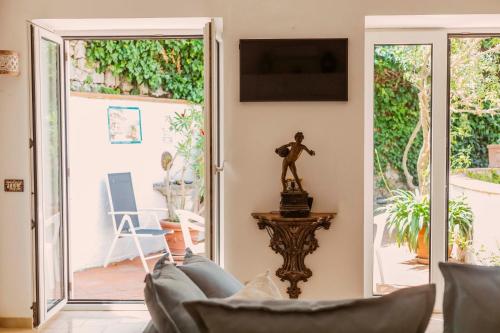 a living room with a couch and a sliding glass door at Casa Silvana, Capri - Relaxando en el verde in Capri