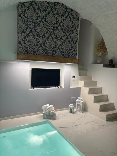 a swimming pool in a room with a tv and stairs at Luxury Suite 23 06 in Casamassima