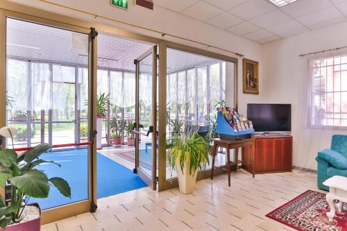 - un salon avec une piscine et des portes coulissantes en verre dans l'établissement Hotel Majorca, à Cesenatico