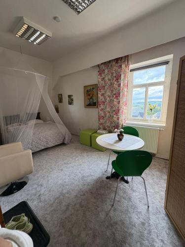 a bedroom with a bed and a table and a window at Nr 5 Doppelzimmer mit Talblick in Annaberg-Buchholz