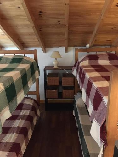 two beds in a room with wooden ceilings at Villa Serena Deportista in Necochea