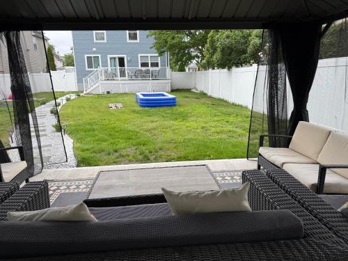 a screened in porch with a couch and a yard at Ground-level bed bath house1mi to the beach sleep8 in Long Branch