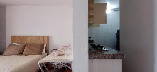 pokój z łóżkiem i kuchnią ze stołem w obiekcie Apartamento Muy Central w mieście Manizales