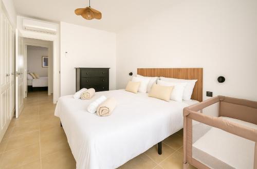 a bedroom with a large white bed with towels on it at Holiday home in meloneras with sea views, golf and private jacuzzi in Maspalomas