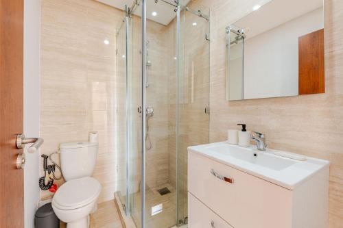 a bathroom with a shower and a toilet and a sink at Luxury Appartement Golf and Pool in Marrakech