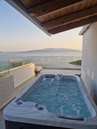 a hot tub on a balcony with a view of the ocean at Penthouse with Jackuzy in Sarandë