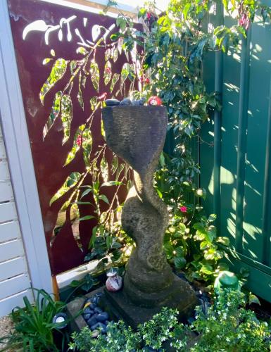 a garden with a statue in the middle of a yard at Coastal Escape in Maroochydore