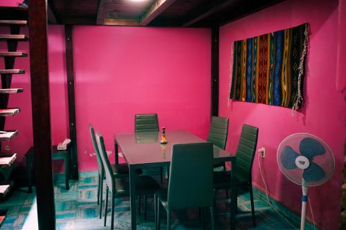 a dining room with pink walls and a table and chairs at La Esmeralda Oaxaca in Oaxaca City