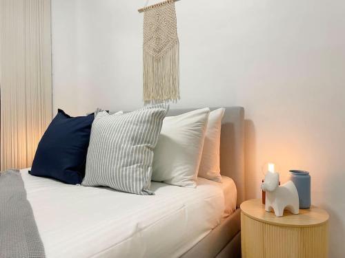 a white couch with pillows and a candle on a table at Views by Day Waves at Night in Caloundra