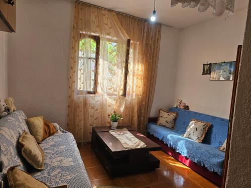 a living room with two blue couches and a table at Villa Pogradeci in Pogradec