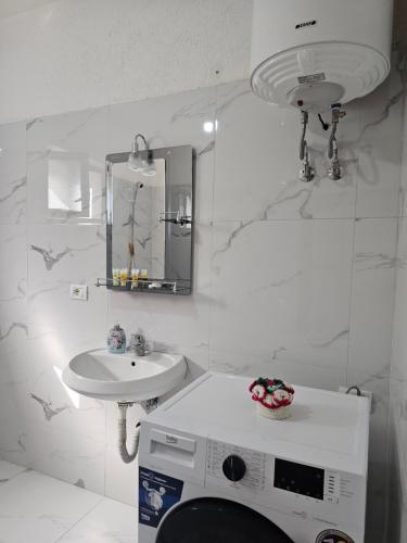 a white bathroom with a sink and a mirror at Villa Pogradeci in Pogradec
