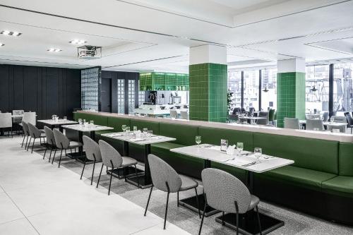 a restaurant with green walls and tables and chairs at Best Western Premier Gangnam Hotel in Seoul