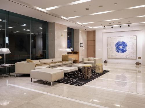 a lobby with couches and tables in a building at Best Western Premier Gangnam Hotel in Seoul