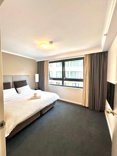 a bedroom with a bed and a large window at 1 Bd Hotel Style Apartment Parramatta in Sydney