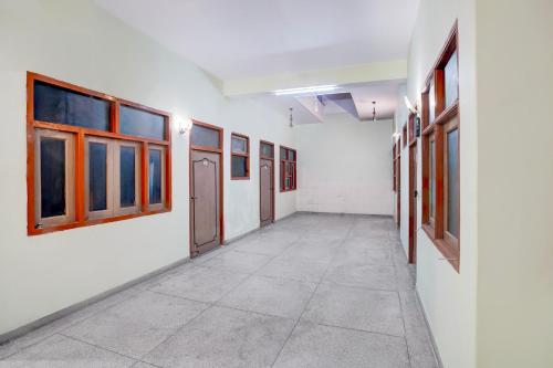an empty corridor in an empty room with windows at Super Hotel O The Comfort in Kānpur