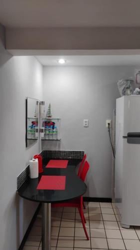 a kitchen with a table and a refrigerator at Boa Viagem Flat BVF 777 in Recife