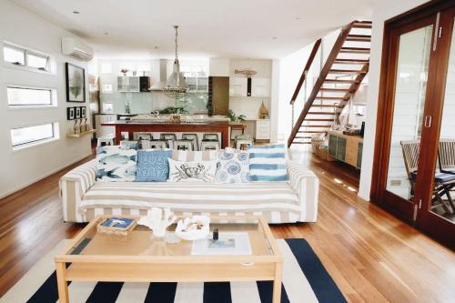 a living room with a white couch and a table at Family Beach House at Twin Waters Resort in Twin Waters