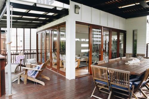 a dining room with a wooden table and chairs at Family Beach House at Twin Waters Resort in Twin Waters