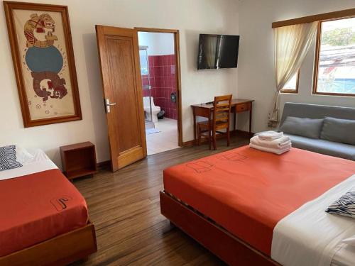 a room with two beds and a couch and a table at Luz de Luna Escalante in San José