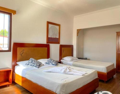 two beds in a hotel room with two beds at Luz de Luna Escalante in San José