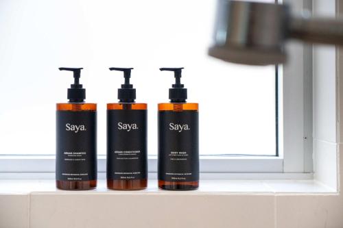 three bottles of sunscreen sitting on a window sill at Absolute Beachfront Marcoola - Private Pool - Private Spa Bath - Games in Marcoola