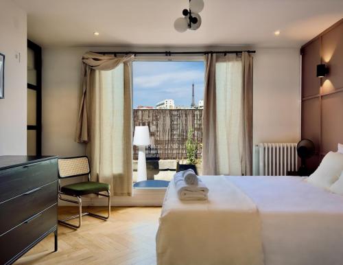 une chambre d'hôtel avec un lit et une grande fenêtre dans l'établissement Cocoon 6p, Terrace with Eiffel Tower & Seine View, à Paris