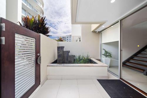 a hallway of a house with a balcony with plants at Absolute Beachfront Marcoola - Private Pool - Private Spa Bath - Games in Marcoola