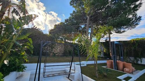 a garden with a swing and some trees at Villa de Campagne in Es Somaa