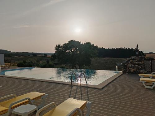 a swimming pool on a roof with chairs around it at Herdade Monte Novo Do Pocinho in Cercal