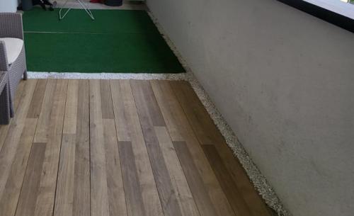 a room with a wooden floor and a green rug at Luxe Central Living Apartment in Debrecen