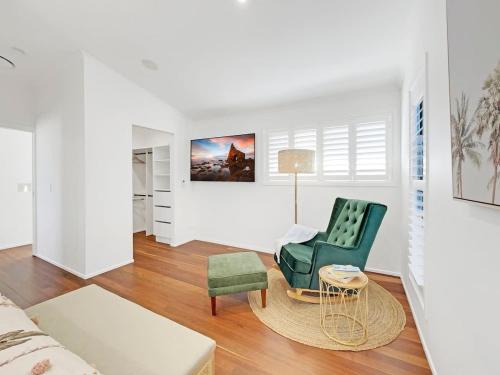 a living room with a green chair and a couch at Mudjimba Beach Haven - Stroll to the Water in Mudjimba