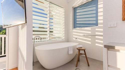 Coen by the Sea في ساحة كاسوارينا: حمام أبيض مع حوض استحمام ونافذة
