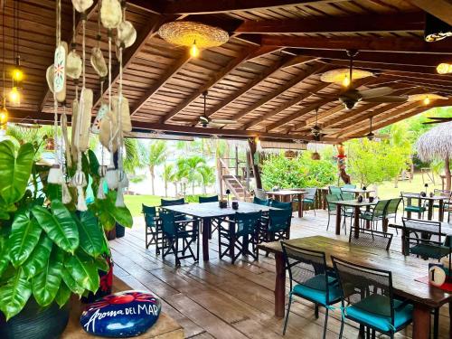 an outdoor patio with tables and chairs and tables and chairs at Roma del mar - Vila s bazénem a krásným výhledem na moře in Paquera