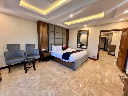 a hotel room with a bed and a chair at Mehboob international hotel murree in Murree