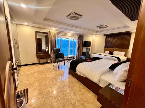 a hotel room with a large bed and a desk at Mehboob international hotel murree in Murree