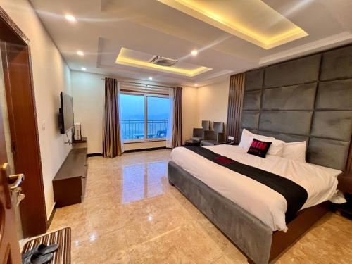 a bedroom with a large bed and a television at Mehboob international hotel murree in Murree